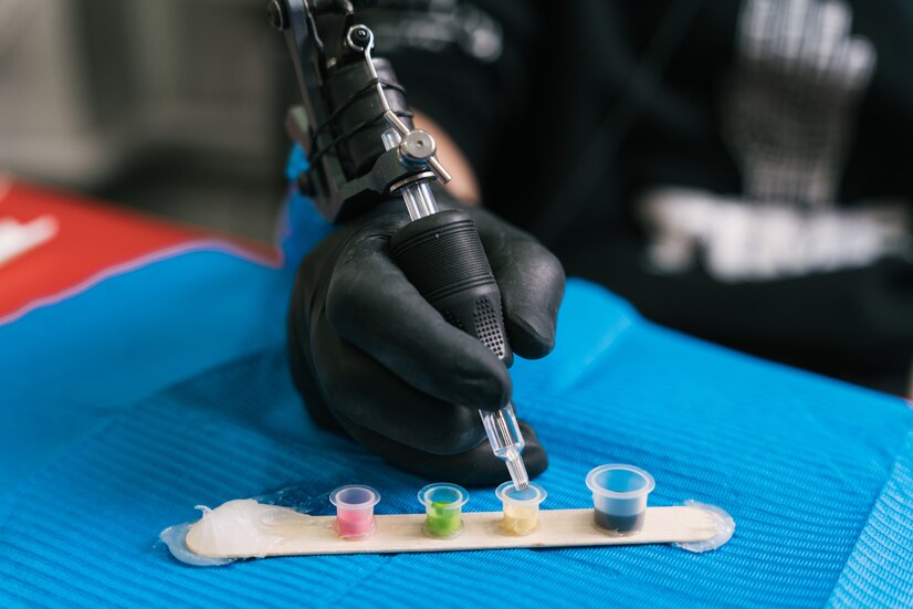 closeup-shot-tattoo-artist-mixing-colors-plastic-cup_181624-9550